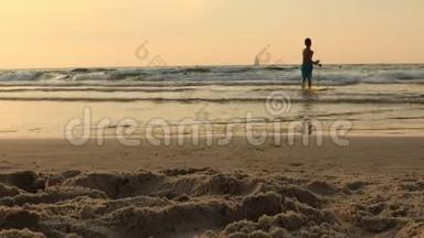 快乐男孩玩，跑，骑在黑板上。 儿童和冲浪概念，日落时在海滩上冲浪